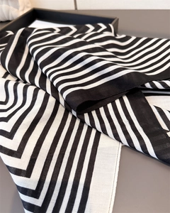 Gros plan sur la texture en lin de coton du foulard rayé géométrique noir et blanc