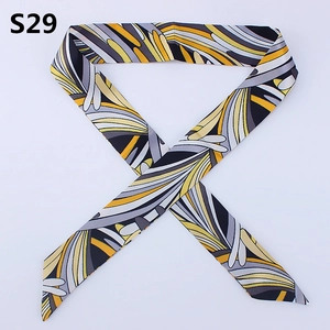 Close-up of slender twilly scarf with abstract swirl pattern in yellow and grey