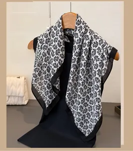 Détail d'une écharpe en coton et lin à motif cachemire sur un cintre en bois