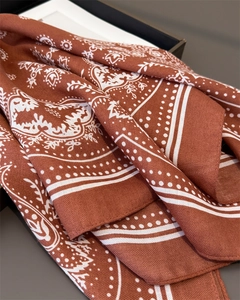 Detailaufnahme des rostroten Paisley-Schals mit eleganter Köperstruktur und klassischen Mustern