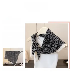 Détail d'un foulard carré noir et blanc à motif paisley avec une texture effet soie luxe
