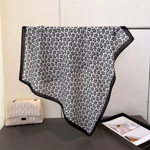 Carré de soie élégant à motif paisley noir et blanc suspendu sur un support en métal
