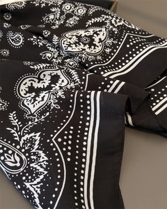 Detailaufnahme des Retro-Paisley-Musters auf dem schwarz-weißen Fischgräten-Stoff