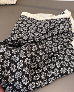 Détail d'un foulard doux en coton et lin noir avec motif paisley et bordure contrastée