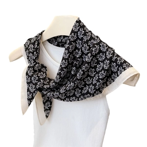 Carré de soie noir et blanc à motif cachemire noué sur un modèle en coton et lin
