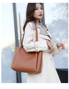 Close-up of a brown leather tote bag showing detailed texture and long shoulder straps