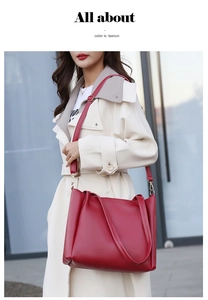 Detail of dark red tote bag with dual handles and adjustable strap on a model