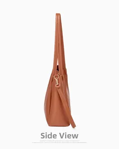 Side view of brown leather tote bag showing golden metal hooks and detachable strap