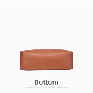 Detailed bottom view of brown leather handbag showing premium stitching and structure