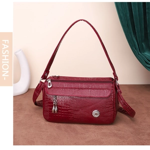 Dettaglio della borsa bordeaux effetto coccodrillo con zip argento e decoro strass