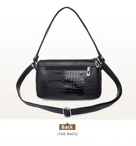 Vista posteriore di una borsa a tracolla nera a motivo coccodrillo con tasca con zip