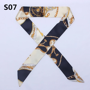 Detail of luxury silk twilly scarf with vintage carriage wheel and gold chain pattern