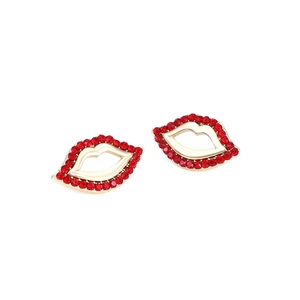 Détail de boucles d'oreilles lèvres en strass rouges avec cadre doré sur fond blanc