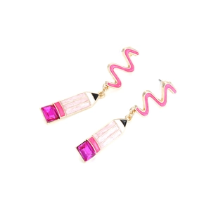 Détail de boucles d'oreilles crayons en émail rose avec strass et finitions dorées