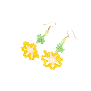 Détail de boucles d'oreilles fleurs en perles faites main avec cristaux jaunes et feuilles