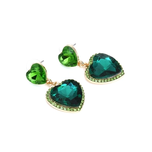 Dettaglio di orecchini a cuore in cristallo verde con strass smeraldo su base dorata