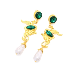 Detail view of vintage phoenix earrings with green gemstones and white teardrop pearls