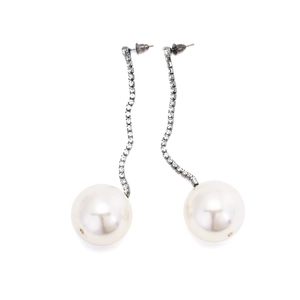 Detailed view of long tassel earrings with large faux pearls and sparkling rhinestones