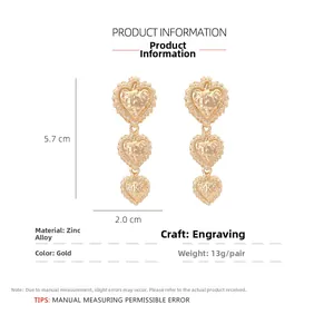 Detail view of gold textured triple heart earrings showing 5.7cm height and dimensions