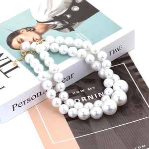 Double-layered baroque pearl necklace with gold clasp on a fashion magazine background