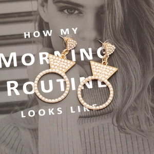 Elegant gold pearl-encrusted earrings in diamond ring shape on a fashion magazine