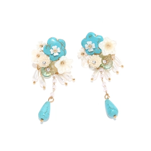Vintage floral tassel earrings with blue stones and pearls on a white background