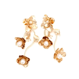 Vintage-Ohrhänger aus goldfarbenem Metall mit Blumen und weißen Perlen auf weißem Grund