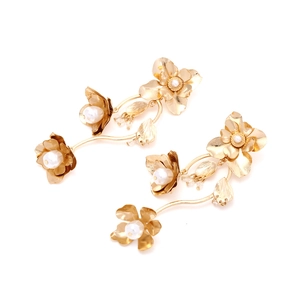 Detailaufnahme goldener floraler Ohrringe mit Perlen und kaskadierenden Metallblättern