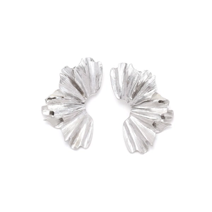 Macro detail of silver ginkgo leaf earrings with pleated metal texture and artistic finish
