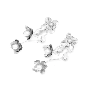 Detailansicht silberner Blumen-Ohrhänger mit Metallblättern und weißen Perlenverzierung