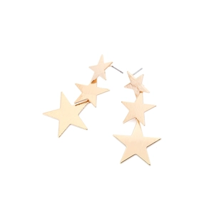Detail of layered gold star earrings featuring a distinct brushed metal texture surface