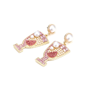 Detailed view of gold wine glass earrings with pink crystals and white pearls decoration