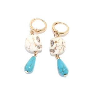 Close-up of bohemian skull earrings with turquoise teardrop and gold hoop details