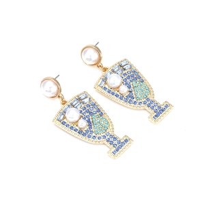 Detailed view of gold wine glass earrings with blue crystals and white pearls