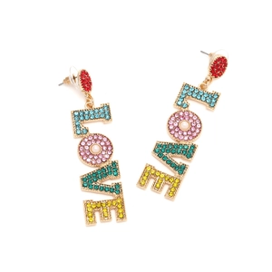 Detailed shot of LOVE letter drop earrings with multi-colored crystals and pearl accent