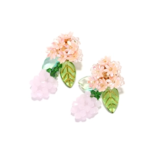 Close-up of handmade pink floral earrings with green leaf charms and crystal beads