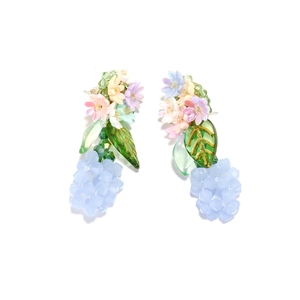 Macro detail of handmade floral drop earrings with pink petals and green leaves