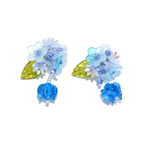 Gros plan détaillé de boucles d'oreilles fleuries perlées avec pétales bleus et feuilles