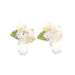 Détail de boucles d'oreilles muguet fait main avec boutons blancs et feuilles vertes