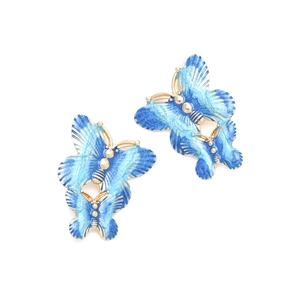 Detail of double-layered blue enamel butterfly earrings with golden metal borders
