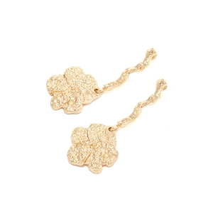 Detail of golden long drop flower earrings with hammered texture and wavy posts