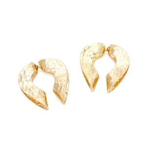 Macro shot of gold hammer-textured metal earrings with double layer hollow heart design