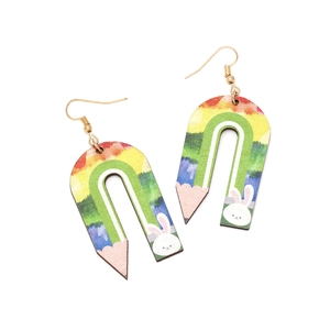 Close-up of wooden U-shaped pencil earrings with rainbow colors and white rabbit pattern