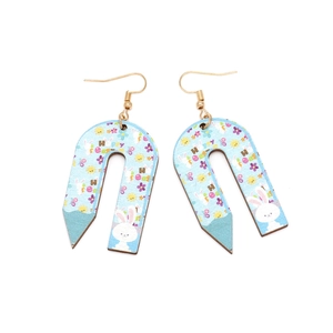 Detailed view of U-shaped pencil earrings with rabbit patterns and golden hooks