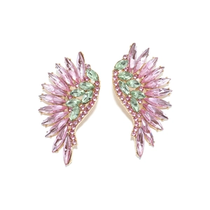 Detailed macro view of gold alloy wing earrings with pink and green rhinestones