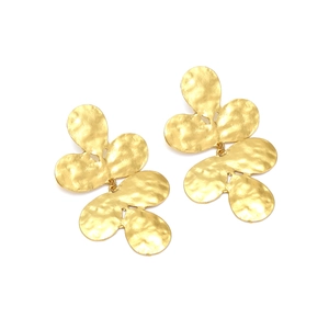 Détail macro de boucles d'oreilles feuilles dorées avec texture métal martelé