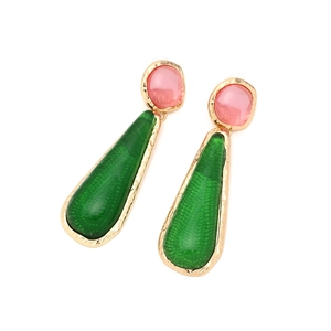 Detail of vintage teardrop resin earrings with pink stone and green pendant in gold frame