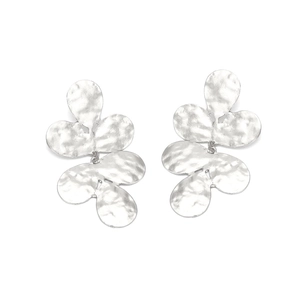 Détail macro de la texture martelée argentée sur les boucles d'oreilles à pétales