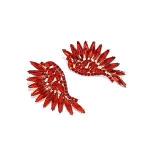 Detailed view of wing-shaped earrings with red marquise crystals in gold setting