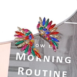 Detailed close-up of colorful rhinestone wing earrings with vibrant gemstone inlay